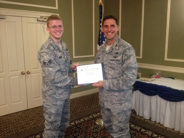 Senior Airman Weston Brown, USAF (l), SACCS online maintenance technician, Air Combat Command (ACC) 55th Strategic Communications Squadron (SCS), Offutt Air Force Base, and Col. Routsis shake hands in September. Senior Airman Brown received one of the chapter's scholarships for $1,000. He is enrolled in Bellevue University where he is pursuing a bachelor of science degree in systems network administration.